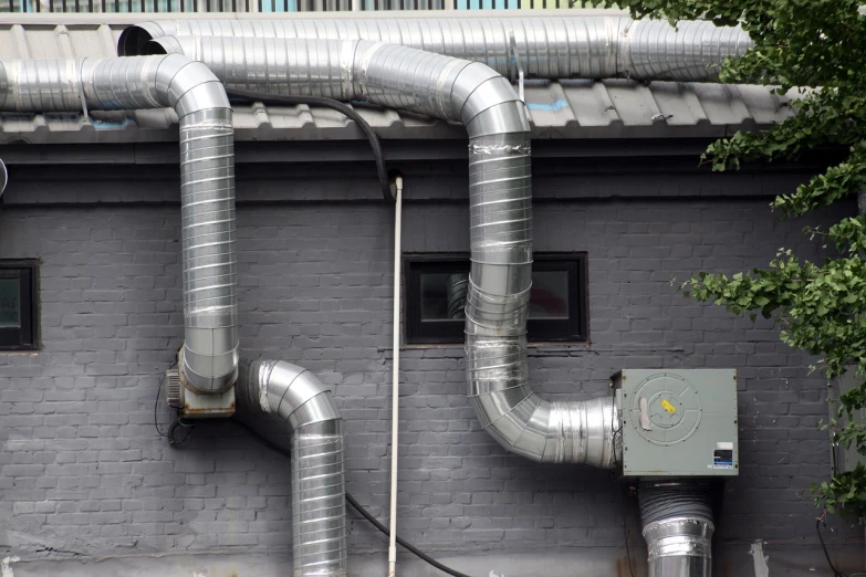 a couple of pipes that are on the side of a building, a photo, shutterstock, grey metal body, wiring, vent, rubber hose style