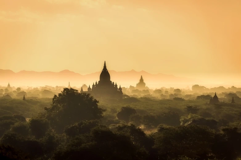 a view of a pagoda in the distance with trees in the foreground, by Thomas Bock, unsplash contest winner, hazy sun and mystical, large temples, istock, hindu temple in background