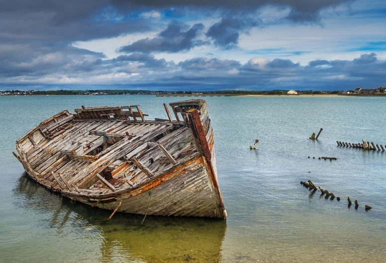 a wooden boat sitting on top of a body of water, by Raymond Normand, shutterstock, derelict, wide panoramic shot, te pae, victorian