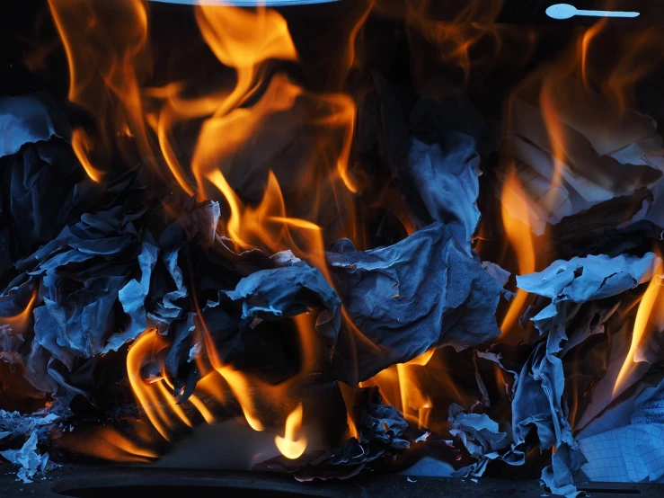 a pile of paper sitting on top of a fire, a screenshot, by Aleksander Gierymski, shutterstock, baroque, breathing blue fire, closeup photo, stock photo, shade