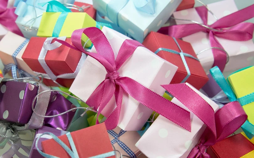 a pile of colorful wrapped presents sitting on top of a table, happening, blushing, wide ribbons, up close picture, pink