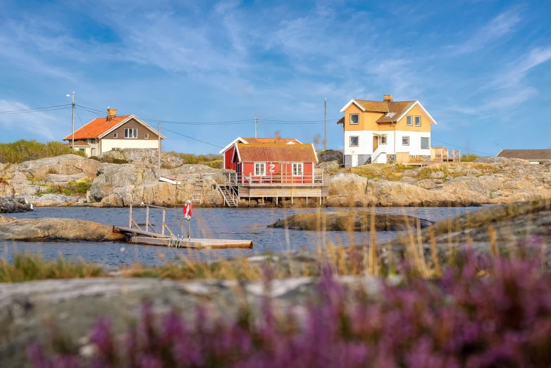 a small boat sitting on top of a body of water, by Wilhelm Marstrand, shutterstock, swedish houses, on island, flowers around, ultra wide-shot