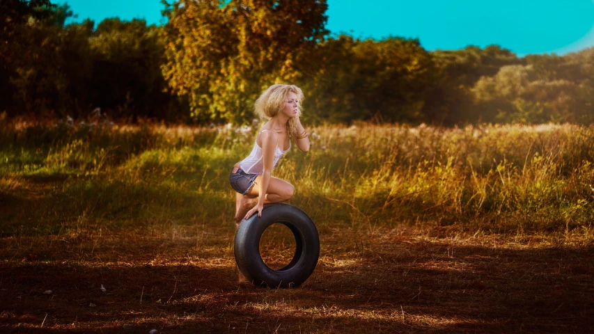 a woman sitting on top of a tire in a field, a portrait, by Galen Dara, trending on pixabay, blonde women, working out in the field, post-processed, nikolay kopeykin