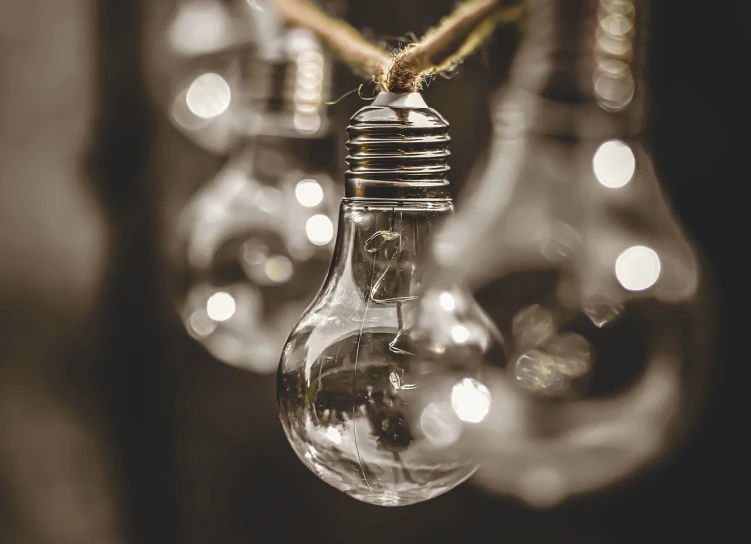 a bunch of light bulbs hanging from a rope, a picture, by Adam Szentpétery, pexels, realism, glowing with silver light, an upright lightbulb, clear focused details, 🦑 design