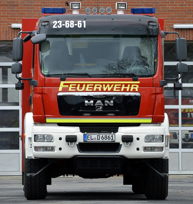 a fire truck parked in front of a building, a picture, by Jakob Gauermann, pixabay, dau-al-set, lower saxony, front face, 1 male, stock photo