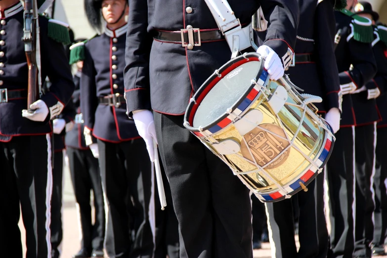 a man in a military uniform holding a drum, by Alison Watt, shutterstock, monaco, wearing presidential band, very detailed picture, high details photo