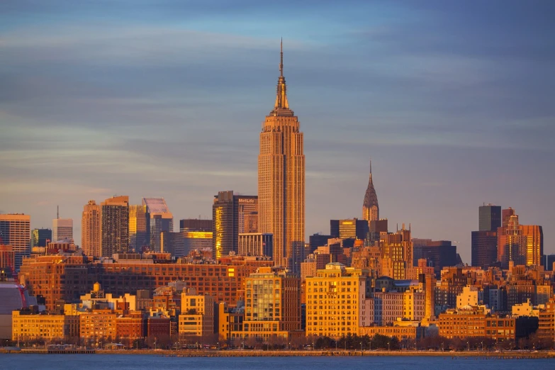 the empire state building towering over the city of new york, by Robert Scott Lauder, shutterstock, backlit golden hour, stock photo