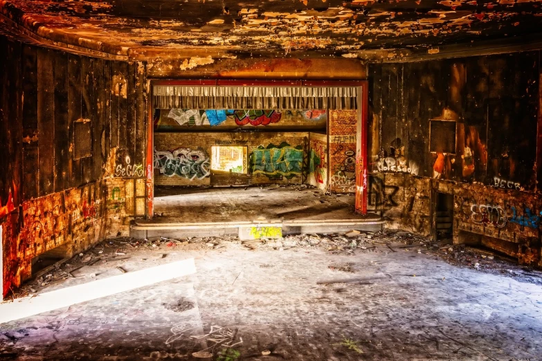 a room with a lot of graffiti on the walls, by Arnie Swekel, flickr, entrance to abandoned mine, theater stage, post processed, room is on fire