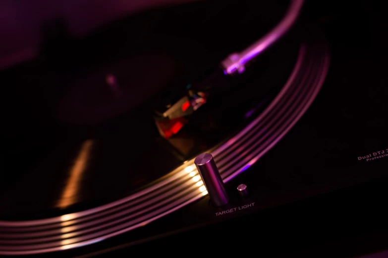 a close up of a record player's turntable, a macro photograph, by Jay Hambidge, holography, barely lit warm violet red light, modern high sharpness photo, highly detailed product photo