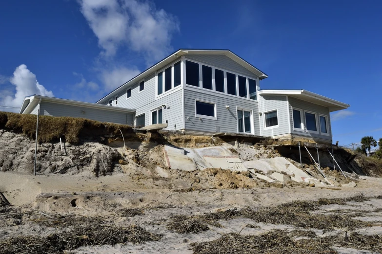 a white house sitting on top of a sandy hill, renaissance, sinkholes, ap photo, coastal, watch photo