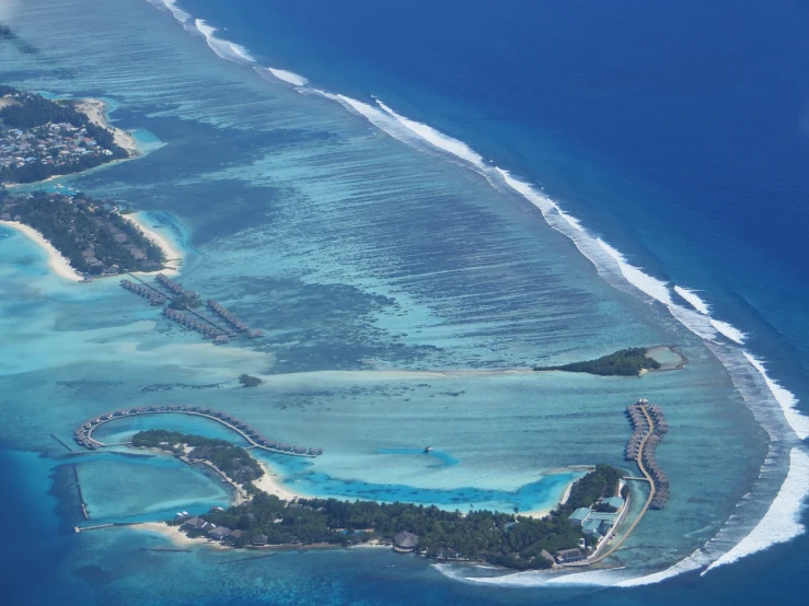 a small island in the middle of the ocean, pexels, hurufiyya, runway, maldives in background, mutiversal tsunami, bottom angle