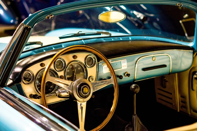 a close up of a steering wheel and dashboard of a car, a picture, by Alexander Bogen, pexels, hypermodernism, turquoise gold details, 1 9 5 0 s style, miniature of a sports car, fantastic vendor interior