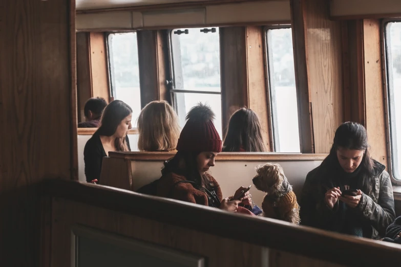 a group of people sitting next to each other, by Christen Dalsgaard, pexels, modernism, ship interior, a dog, teenage girl, with people inside piloting it