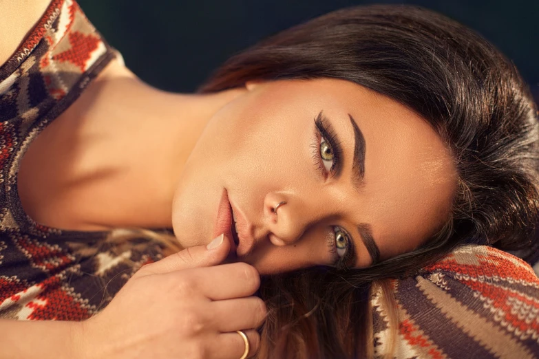 a close up of a woman with a ring on her finger, by Juan O'Gorman, trending on pexels, photorealism, sleepy fashion model face, seductive reclining pose, big bold thick eyebrows, 4 k editorial photograph