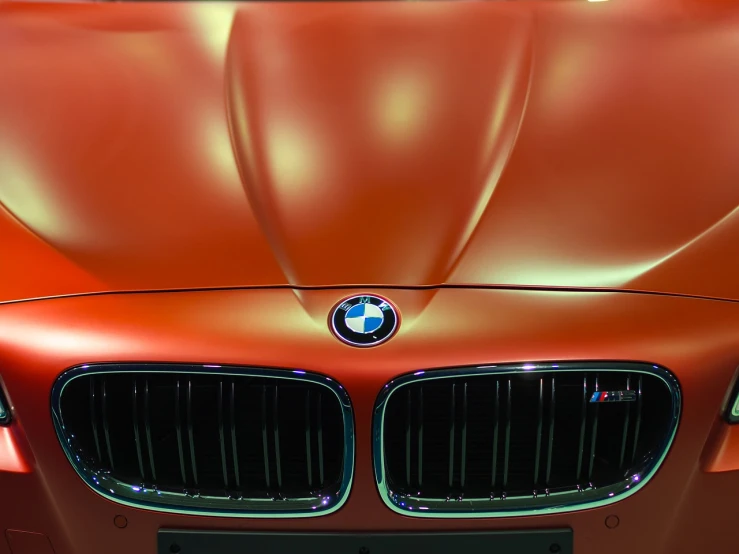 a close up of the front of a car, a photo, by Andrei Kolkoutine, shutterstock, synthetism, bmw, red and orange colored, smooth shiny metal, postprocessed