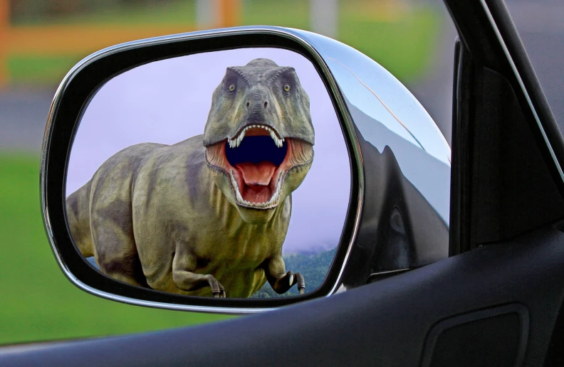 a close up of a car mirror with a dinosaur on it, pixabay, photorealism, very silly looking, roaring, cool marketing photo, the creature sits in a car