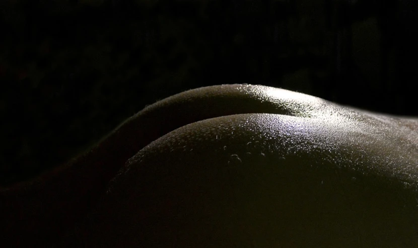 a close up of a person laying on a bed, a macro photograph, by Doug Ohlson, flickr, art photography, acid rains. the sacred nipple, back lit lighting, shiny textured plastic shell, snow on the body