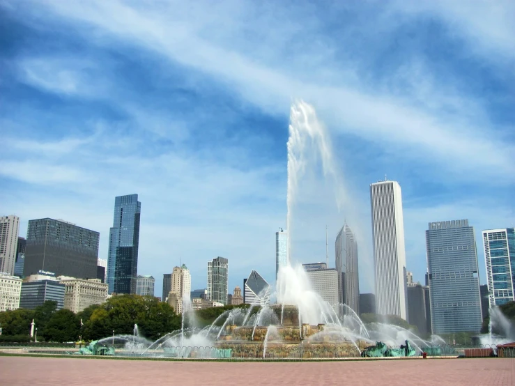 a fountain spewing water in front of a city skyline, inspired by Anish Kapoor, visual art, beautiful sunny day, illinois, tourist destination, video