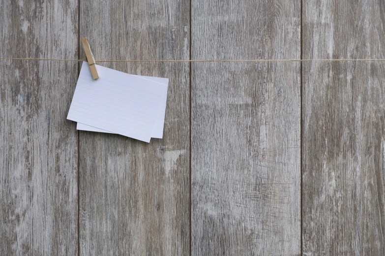 a piece of paper hanging on a clothes line, by Richard Carline, wood texture, whiteboards, grayish, metaphor