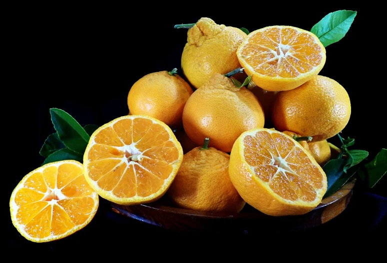 a bowl filled with oranges sitting on top of a table, by Dietmar Damerau, trending on pixabay, in front of a black background, yellow aureole, various posed, [ organic