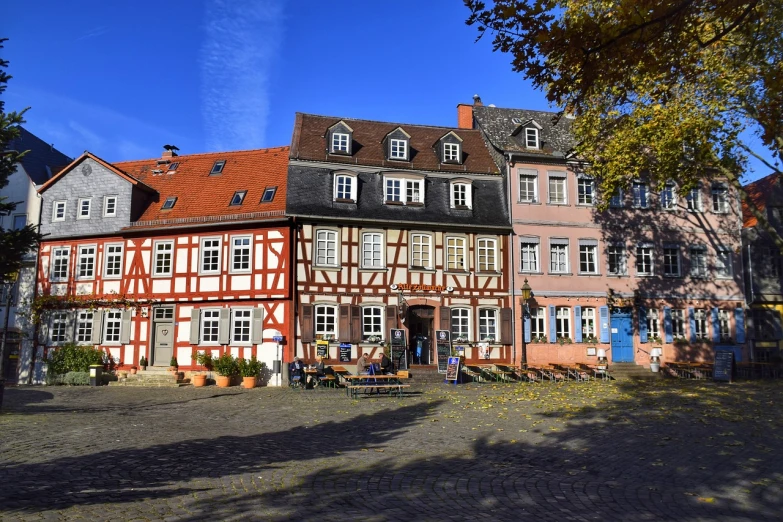 a group of buildings sitting next to each other, by Karl Hagedorn, shutterstock, heidelberg school, in muddy medieval village square, fall season, detmold, blue