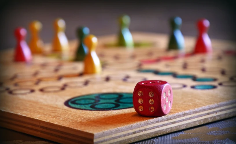 a red dice sitting on top of a wooden board, by Mathias Kollros, trending on pixabay, naive art, shipibo, multi - coloured, focus in the foreground, playing board games