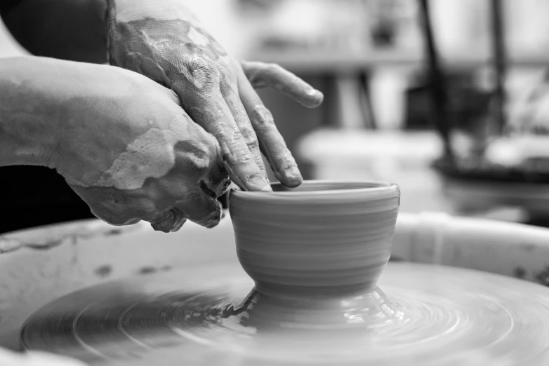 a person making a bowl on a potter's wheel, a black and white photo, inspired by Hendrik Gerritsz Pot, shutterstock, high details photo, porcelain forcefield, hand model, 2019 trending photo