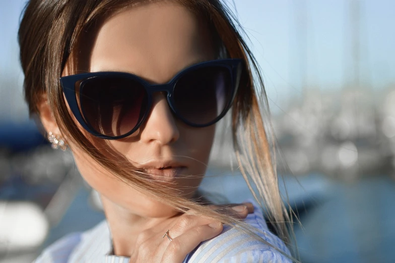 a close up of a woman wearing sunglasses near a body of water, by Mathias Kollros, pixabay, romanticism, fashion shoot 8k, serious business, fierce expression 4k, closeup of an adorable