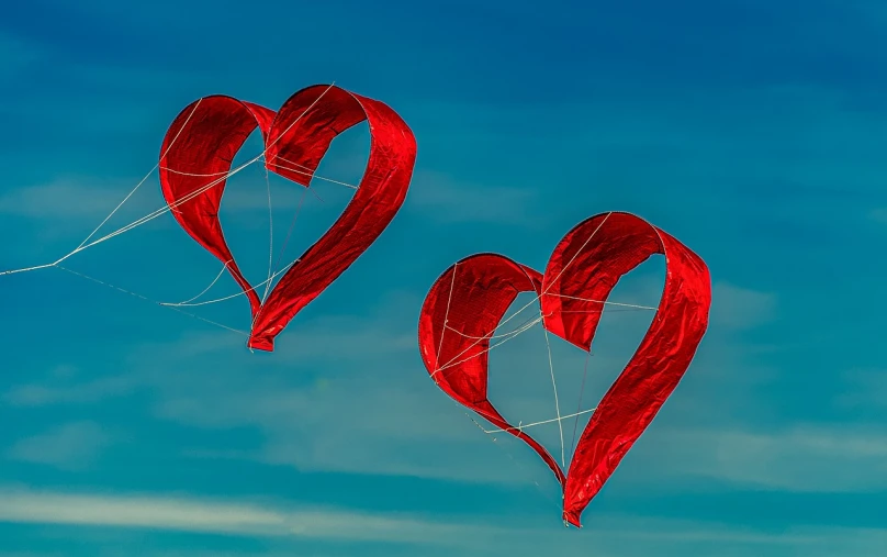 two red heart shaped kites flying in the sky, by Jan Rustem, fine art, photo taken with nikon d 7 5 0, blue sky, intense detail, glass sculpture of a heart