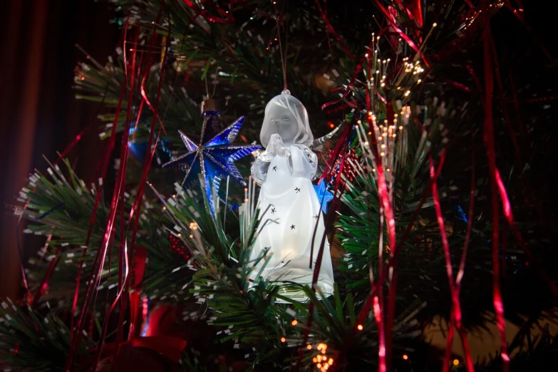 a close up of a christmas ornament on a tree, a portrait, happening, wings made of light, photo taken on a nikon, 2 0 1 0 photo