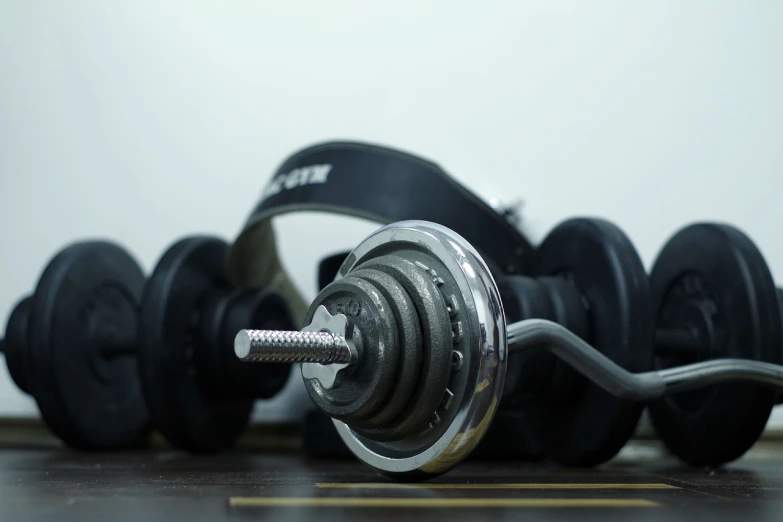 a pair of dumbbells sitting on top of a wooden floor, pexels, dau-al-set, headset, wrench, very very realistic, spinning