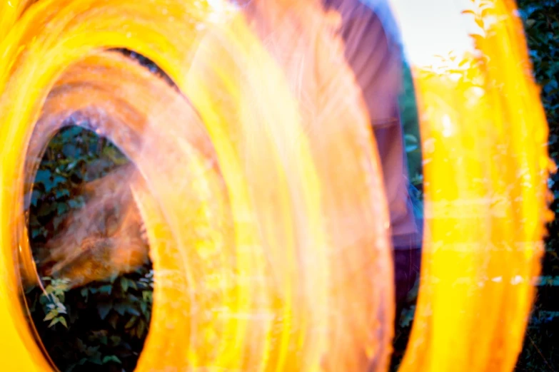 a close up of a person holding a frisbee, by Jan Rustem, flickr, lyrical abstraction, orange yellow ethereal, long exposure 8 k, tubing, swirly bokeh