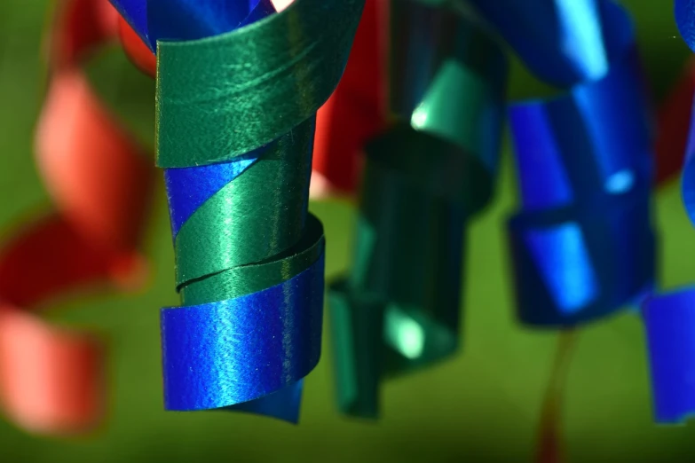 a bunch of blue and green ribbons hanging from a string, a microscopic photo, closeup photo, marvelous designer substance, made from paper, shiny colors