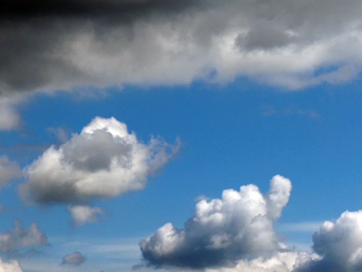 a plane flying through a cloudy blue sky, by Linda Sutton, flickr, precisionism, towering cumulonimbus clouds, mario clouds, melting clouds, blue and gray colors