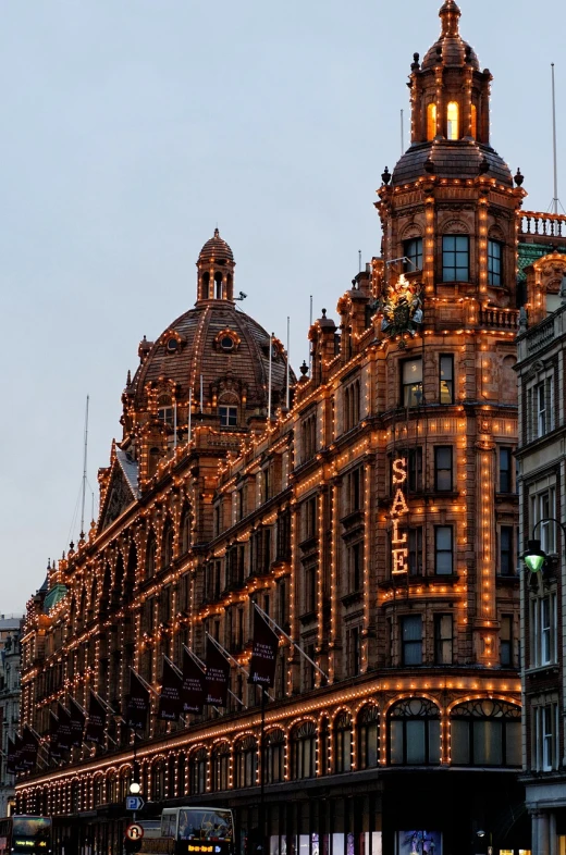 a very tall building with a lot of lights on it, a photo, by Joseph Severn, shutterstock, art nouveau, victorian london, shops, shot on leica sl2, sparkling