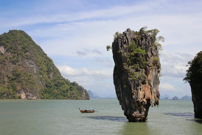 a large rock in the middle of a body of water, a picture, by Richard Carline, shutterstock, thailand, movie set”, creating a thin monolith, stock photo