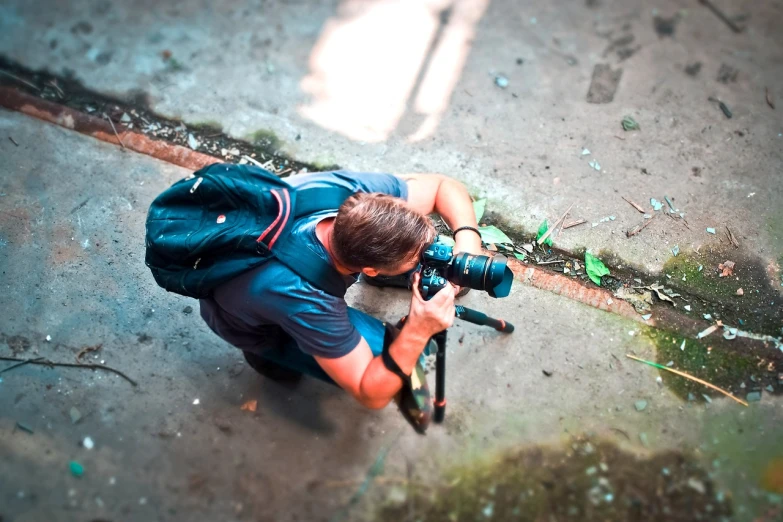 a man that is kneeling down with a camera, a picture, by Jan Rustem, high quality action photography, photo taken from above, tripod, professional photograph