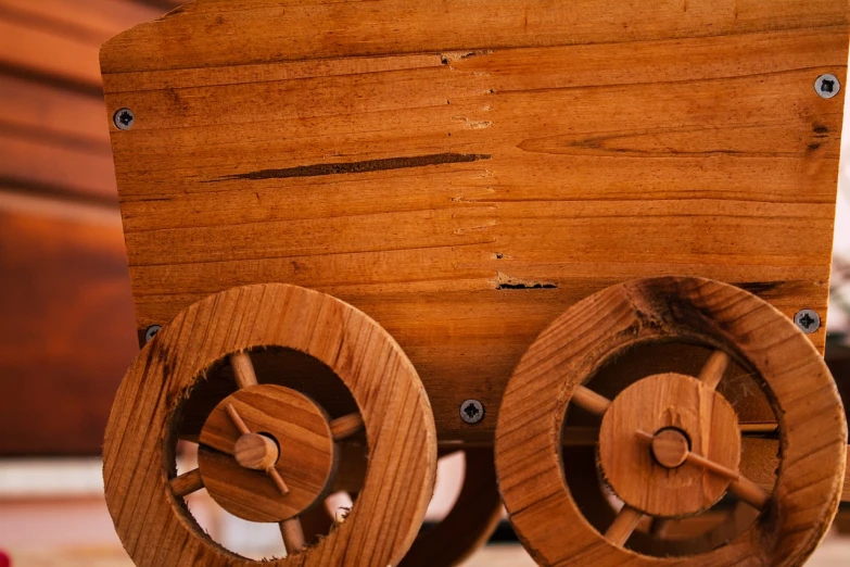 a wooden toy train sitting on top of a table, by Richard Carline, renaissance, leonardo davinci detail, view from bottom to top, cart wheels, polished with visible wood grain