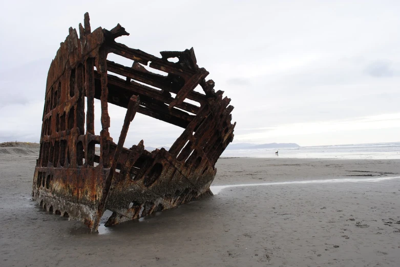 a rusted ship sitting on top of a sandy beach, by Hannah Tompkins, flickr, haida, photo taken of an epic intricate, hollow, wide long view