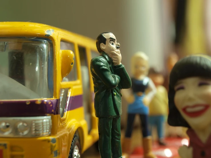 a figurine of a man talking on a cell phone next to a toy bus, flickr, figuration libre, close face view, people panic in the foreground, the cars have faces, school class