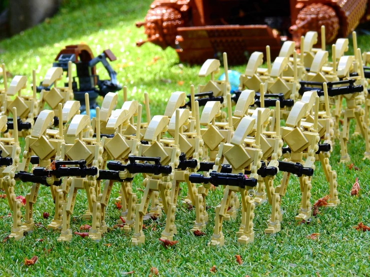 a group of toy soldiers that are standing in the grass, by Edward Corbett, flickr, at - at imperial walkers, brick, many arms, tan