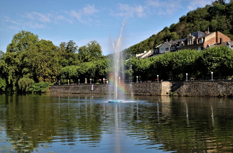 a water fountain in the middle of a lake, a hologram, figuration libre, beautiful tranquil day, rossier, village, otjize