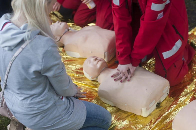 a group of people standing around a dummy, shutterstock, first aid kit, closeup photo, watch photo, beautiful angle