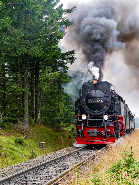 a large long train on a steel track, a picture, by Dietmar Damerau, pixabay contest winner, black forest, smoker, backdrop, leaving for battle