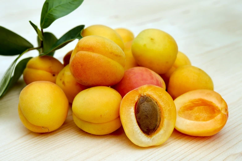 a pile of apricots sitting on top of a wooden table, 3 4 5 3 1, full product shot, profile pic, fruit trees