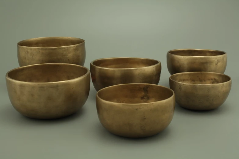 a group of bowls sitting on top of a table, inspired by Kawai Gyokudō, trending on polycount, mingei, brass, ultra wide-shot, 513330673, instrument