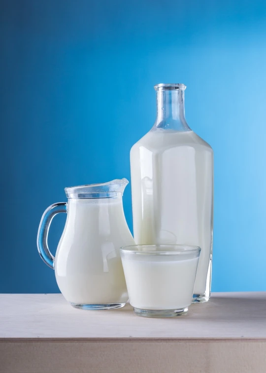 a pitcher of milk next to a glass of milk, a still life, shutterstock, with a blue background, half body photo, jars, with white skin