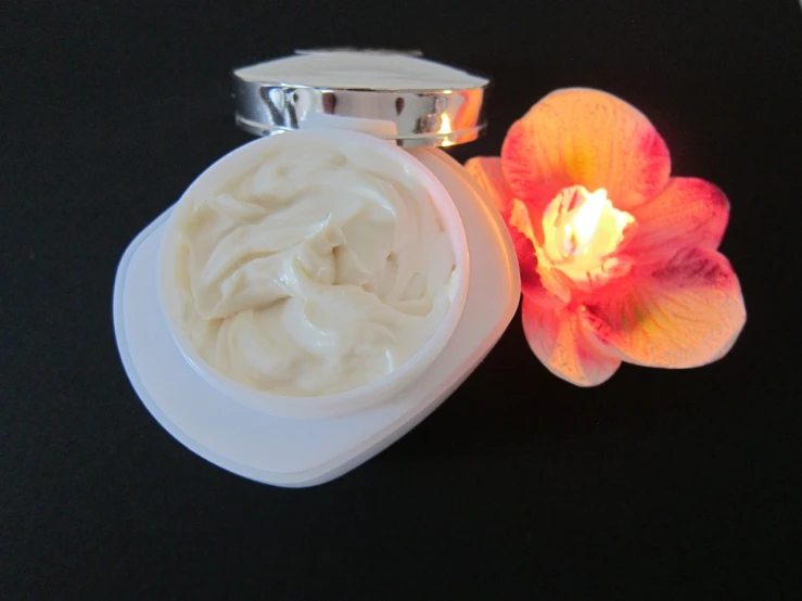 a jar of cream next to a flower on a table, by Dennis Ashbaugh, silicone skin, top view, white shiny skin, hurricane
