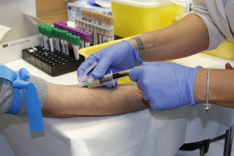 a person in blue gloves is getting a blood test, by Jason Felix, round-cropped, blog-photo, file photo, unedited