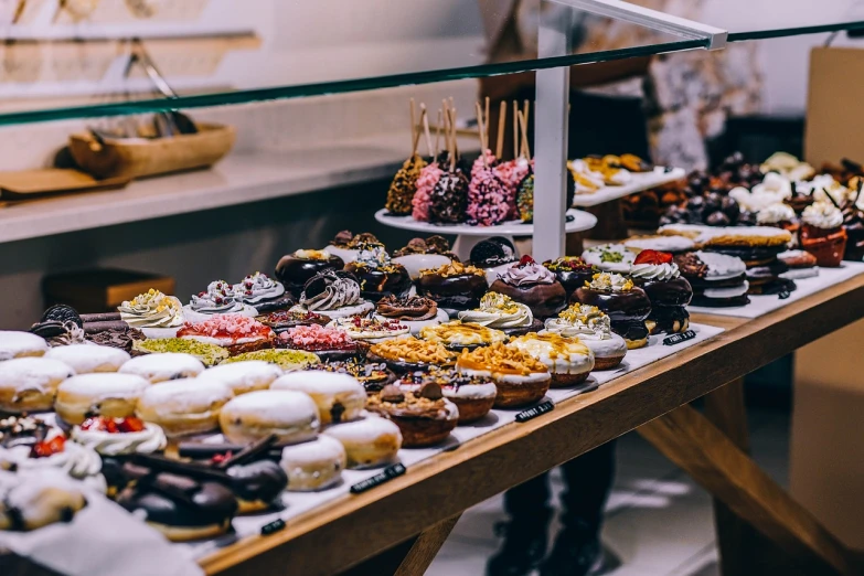 a table topped with lots of different types of pastries, by Niko Henrichon, pexels, hyperrealism, eating a donut, fantastic vendor interior, profile picture, glaze